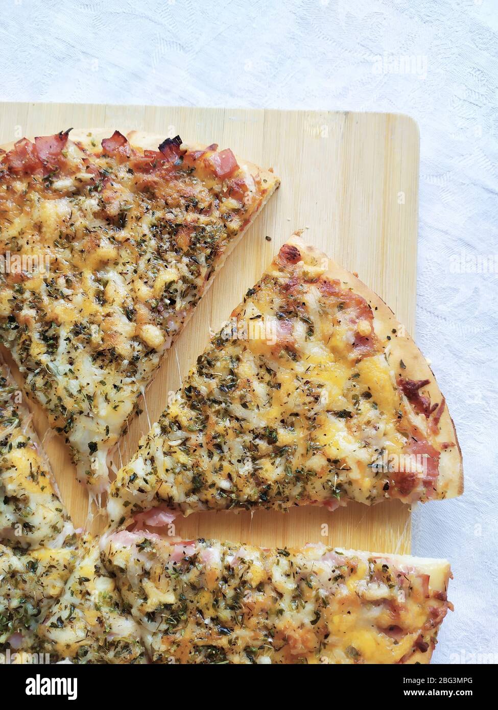 Tranches de pizza sur une planche à découper en bois Banque D'Images