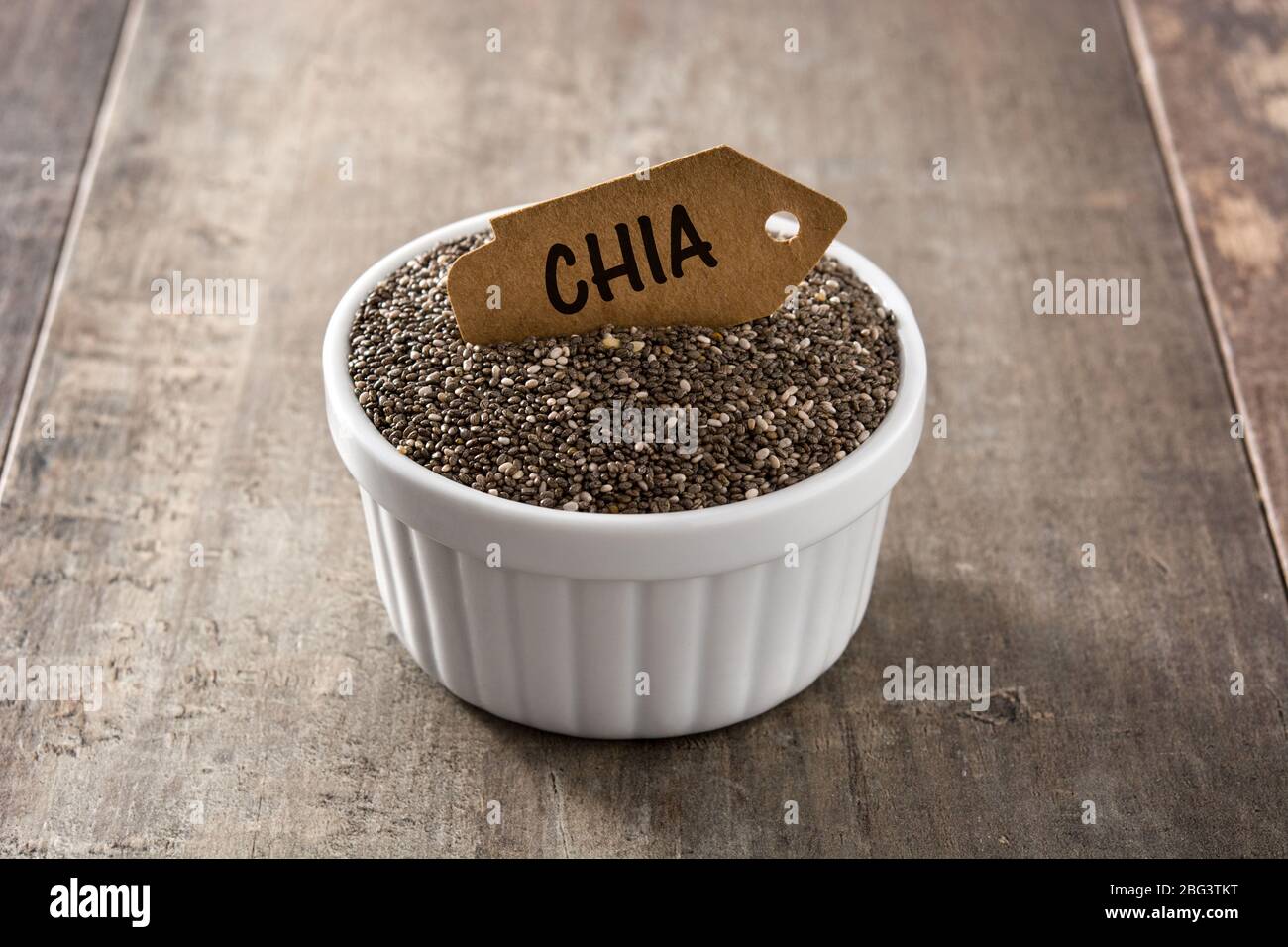 Graines de Chia dans un bol sur table en bois Banque D'Images