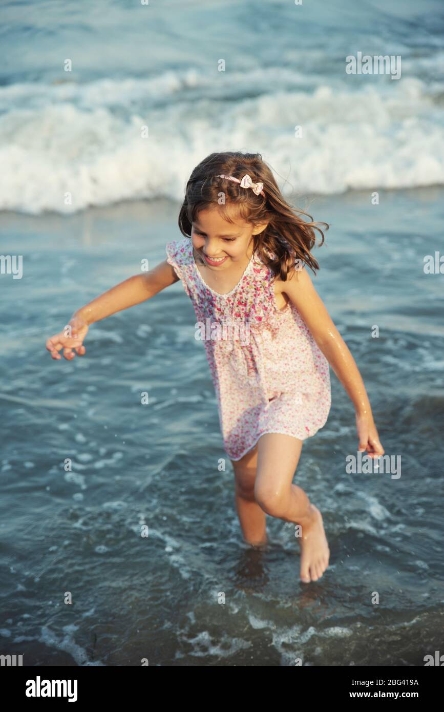 Fille qui courir dans l'océan surf, Bulgarie Banque D'Images