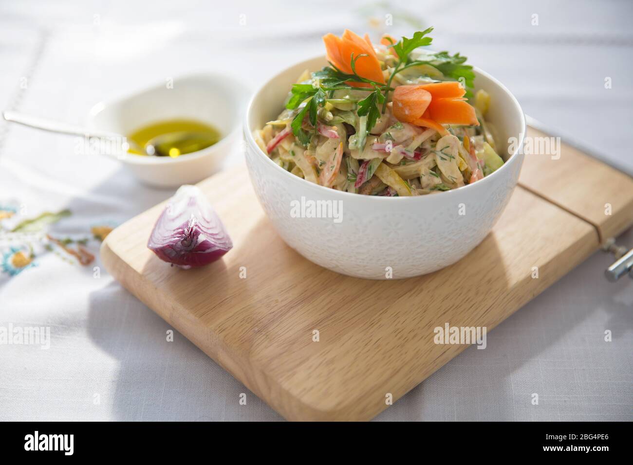 Oignon rouge haché . olives sur un petit bol blanc . planche en bois . Salade de jambon, de poivron rouge et orange, de champignons, de cornichons, de sauce blanche, sur un blanc Banque D'Images