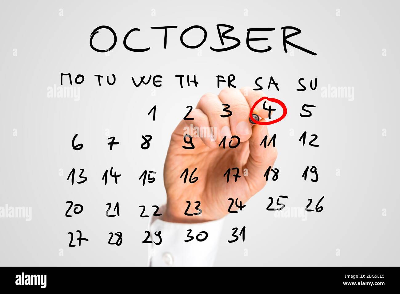 Homme qui sonne la Journée mondiale de l'animal, samedi 4 octobre, en rouge sur un calendrier manuscrit sur une interface virtuelle comme rappel de son importation Banque D'Images