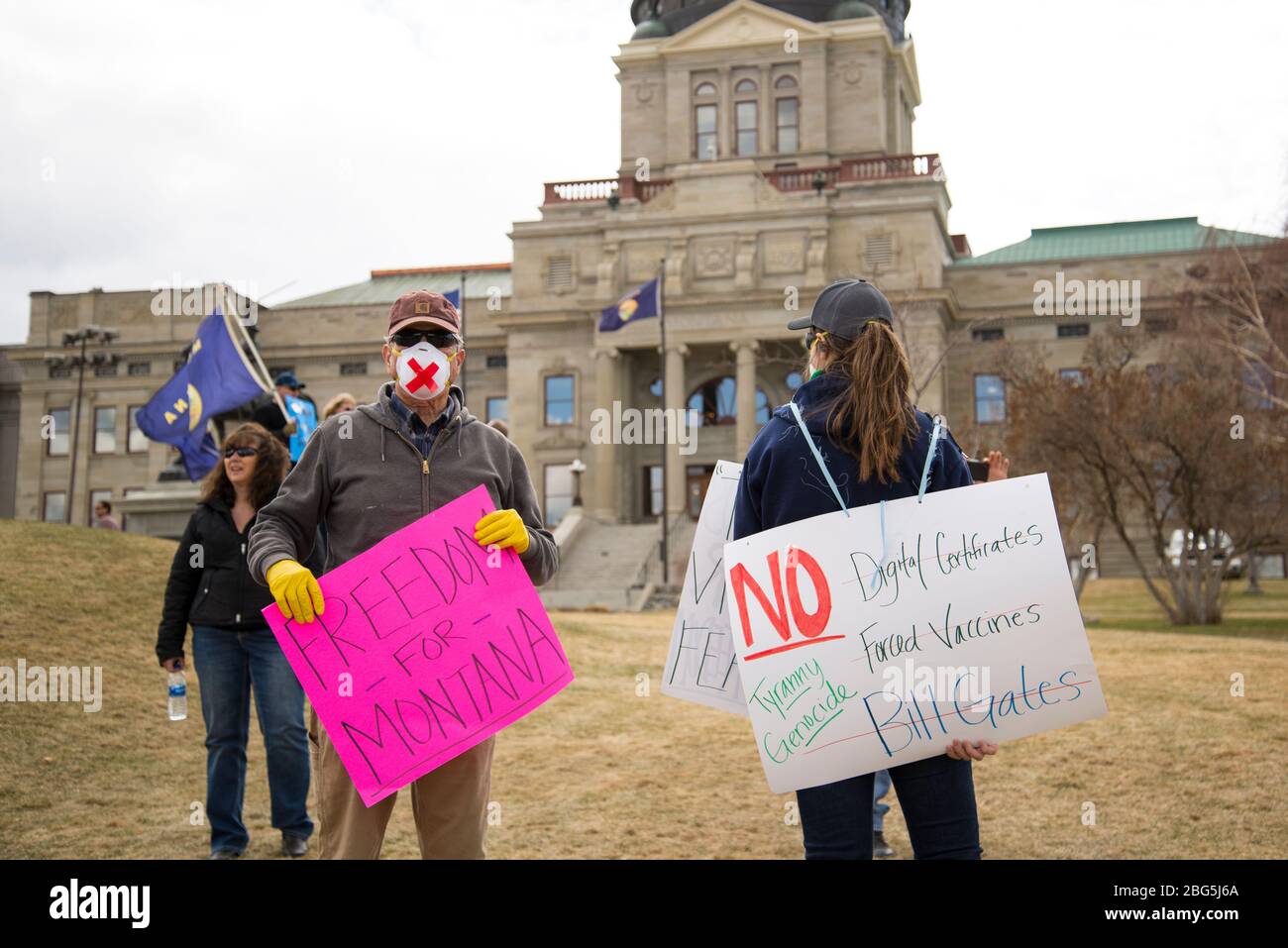 Helena, Montana - 19 avril 2020: Des manifestants protestent au Capitole en portant des masques, des gants et en tenant des panneaux pour la liberté et contre les vaccins, Banque D'Images