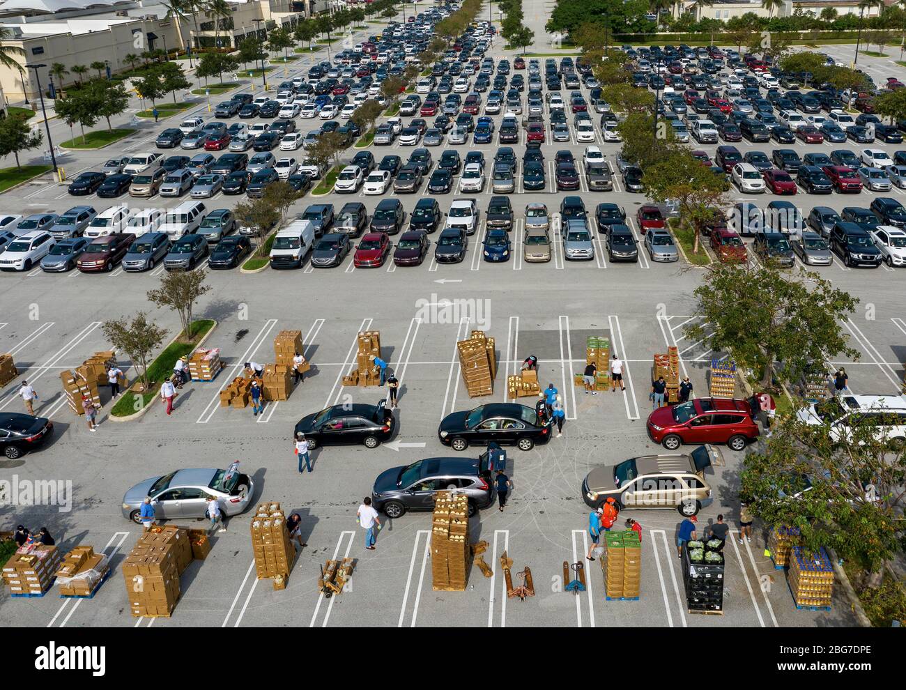 West Palm Beach, Floride, États-Unis. 20 avril 2020. Les voitures se trouvent dans un centre de distribution de nourriture en voiture dans le parking des magasins d'usine de Palm Beach. Les gens reçoivent une semaine d'approvisionnement en protéines, en produits frais, en œufs, en lait et en autres produits essentiels. Les dons sont limités à 800 voitures sur une base de premier arrivé premier servi chaque lundi. Palm Beach Outlets s'est associé à Feeding South Florida pour aider les personnes qui luttent pendant la pandémie de coronavirus. Crédit: Gregg Lovett/ZUMA Wire/Alay Live News Banque D'Images