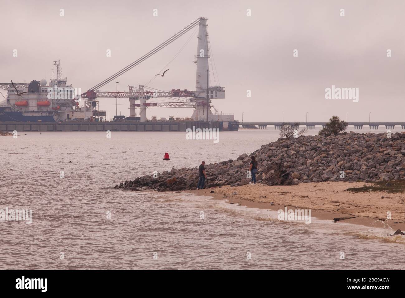 Un couple se trouve près des rochers de Pascagoula point, Pascagoula, Mississippi, États-Unis Banque D'Images