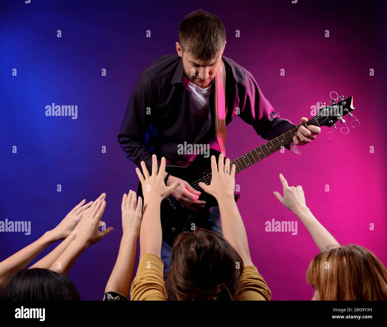Le chant du guitariste sur scène à un concert de rock pour ses fans d'Adoration Banque D'Images