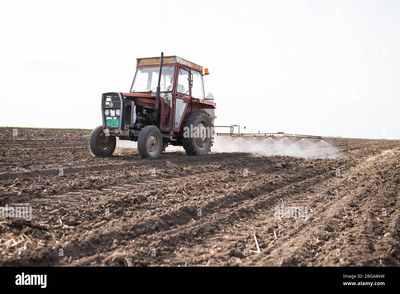 le tracteur pulvérise le champ avant la germination. Banque D'Images