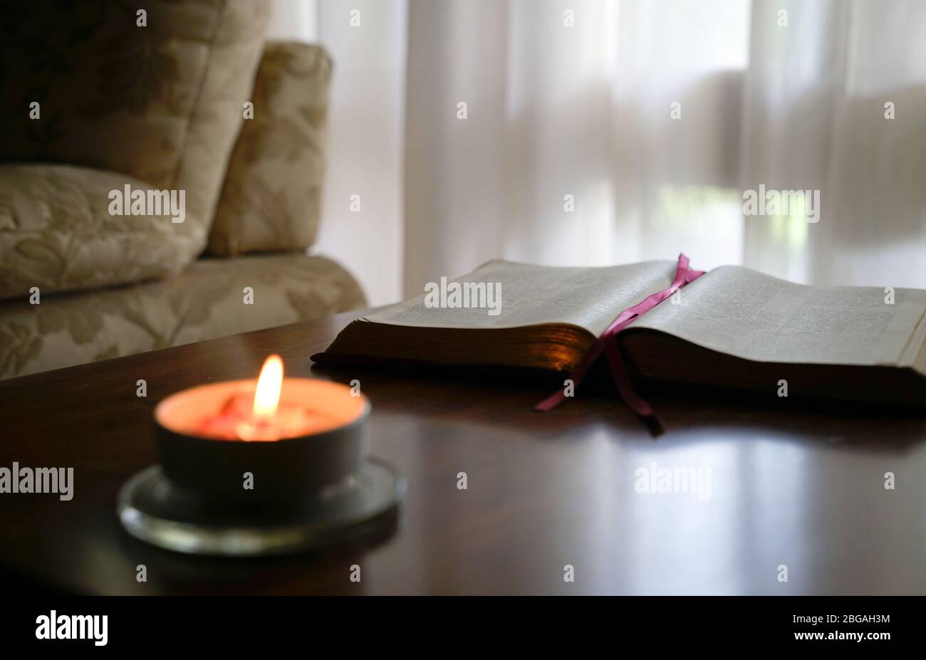 Ouvrir la bible avec bougie brûlante sur la table. Ambiance chaleureuse. Banque D'Images