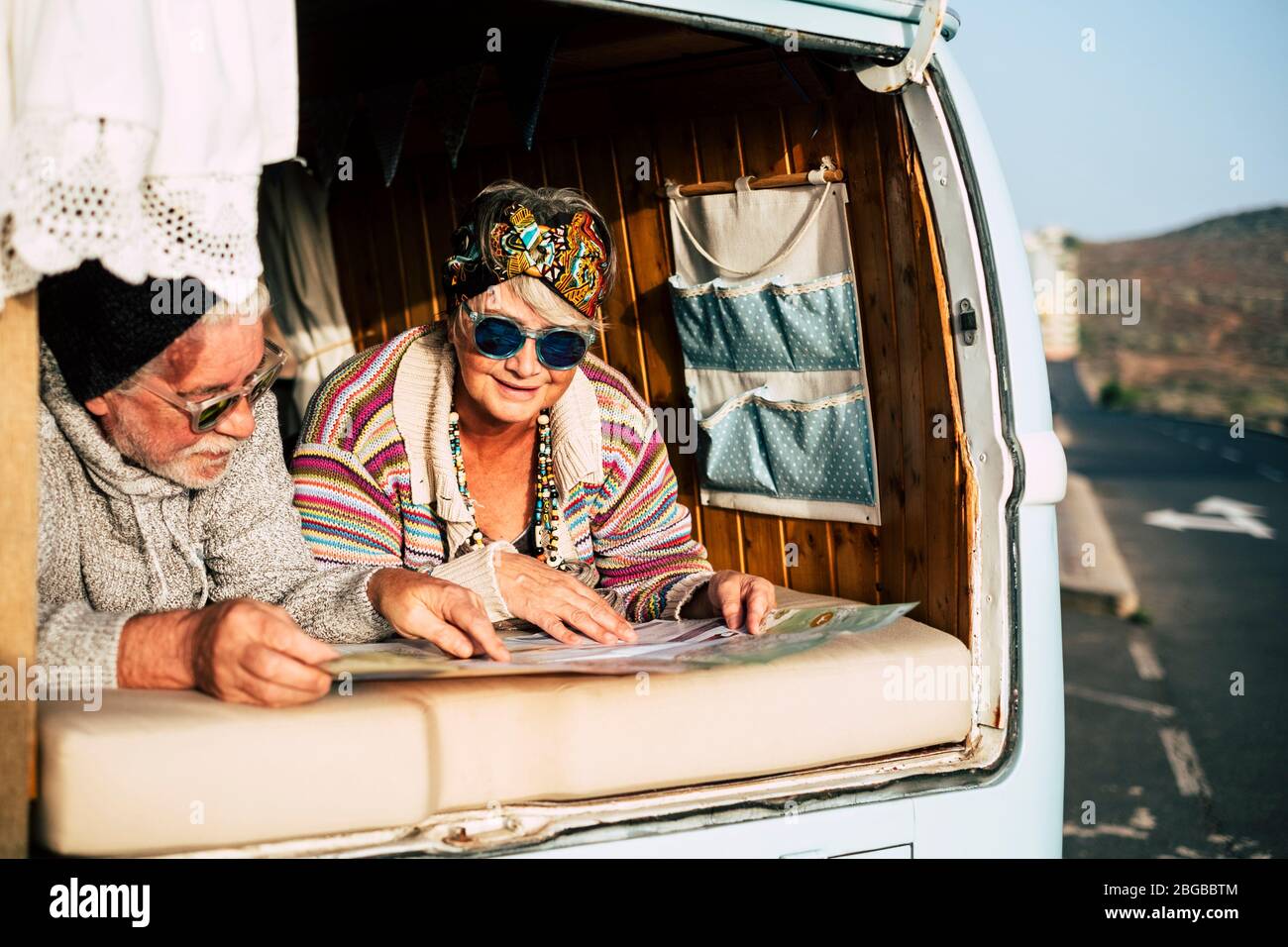 Un couple de personnes âgées heureux appréciez le voyage ensemble dans un vieux véhicule camionnette vintage - concept de changement de vie en âge de retraite - des personnes mûres heureuses à l'intérieur d'un Banque D'Images