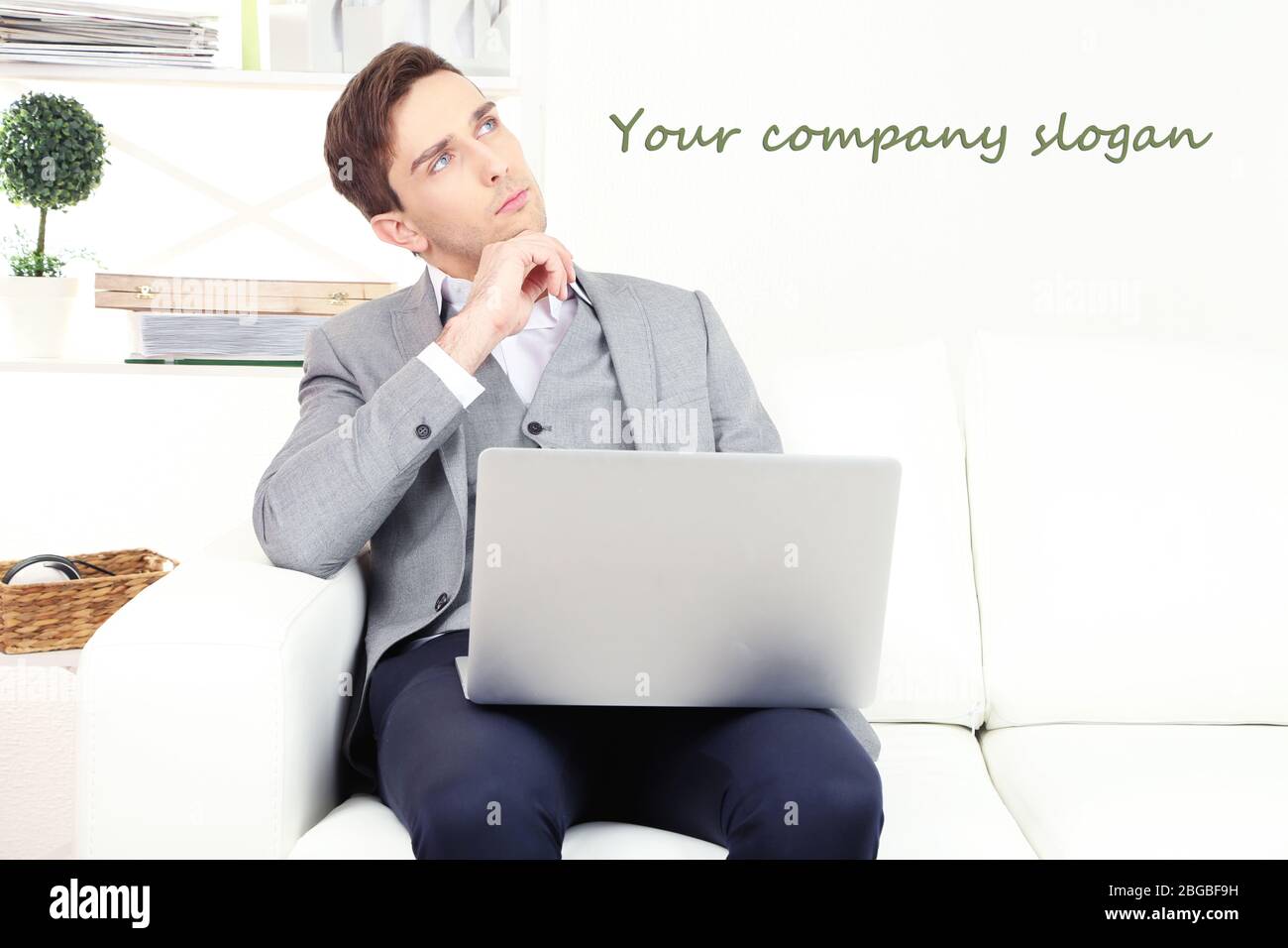 Jeune homme d'affaires utilisant un ordinateur portable sur un canapé à la maison Banque D'Images