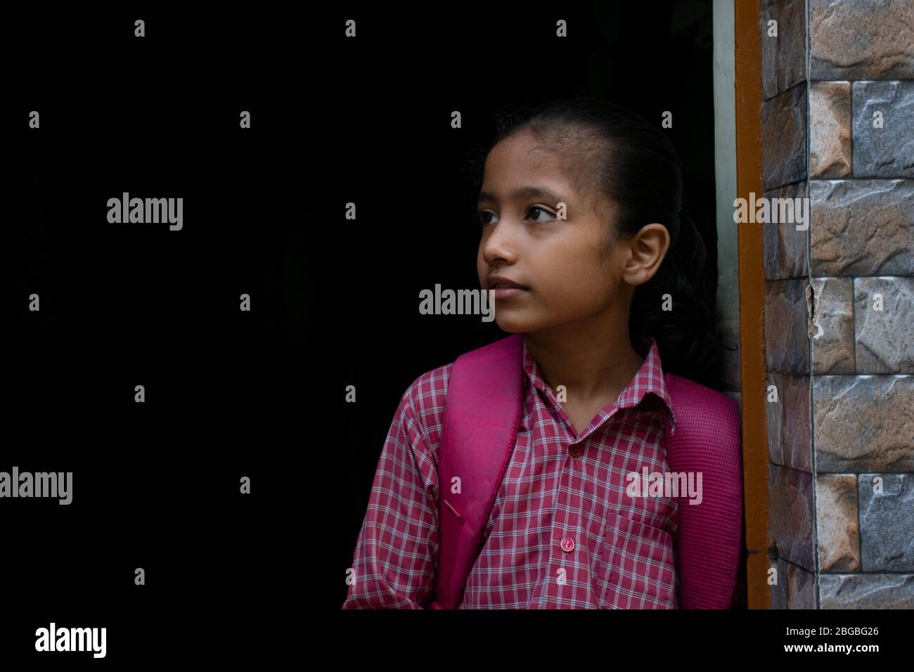 fille d'école debout à la porte avec son sac Banque D'Images