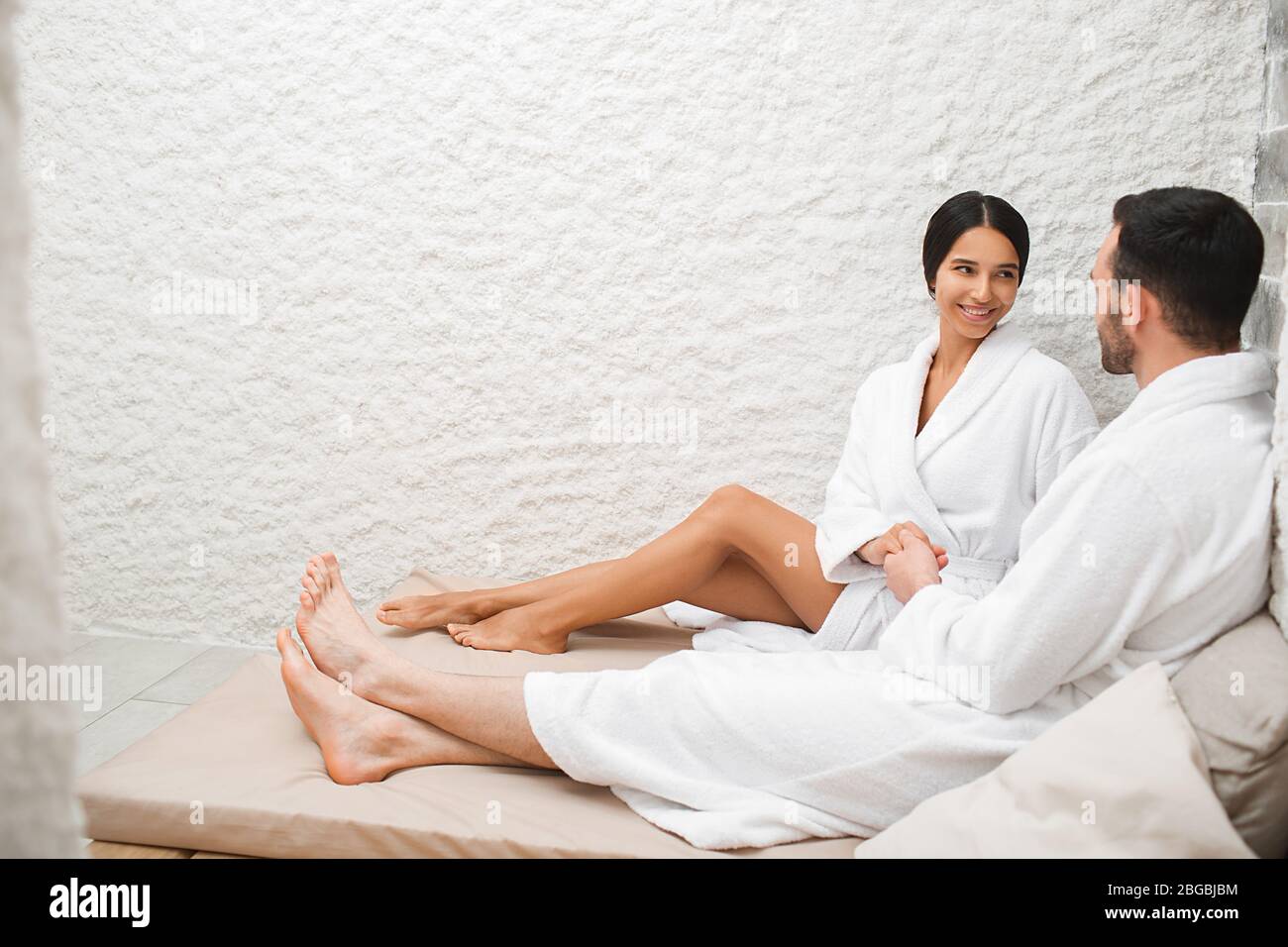 Beau couple mixte de course dans des peignoirs recevant un traitement d'halothérapie. Traitement et romantique date au spa Banque D'Images