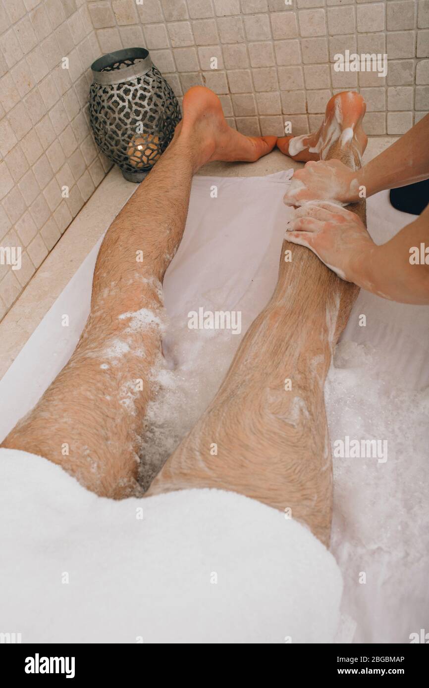 Hamam. Laver la jambe avec de la mousse et du savon dans un bain turc Banque D'Images