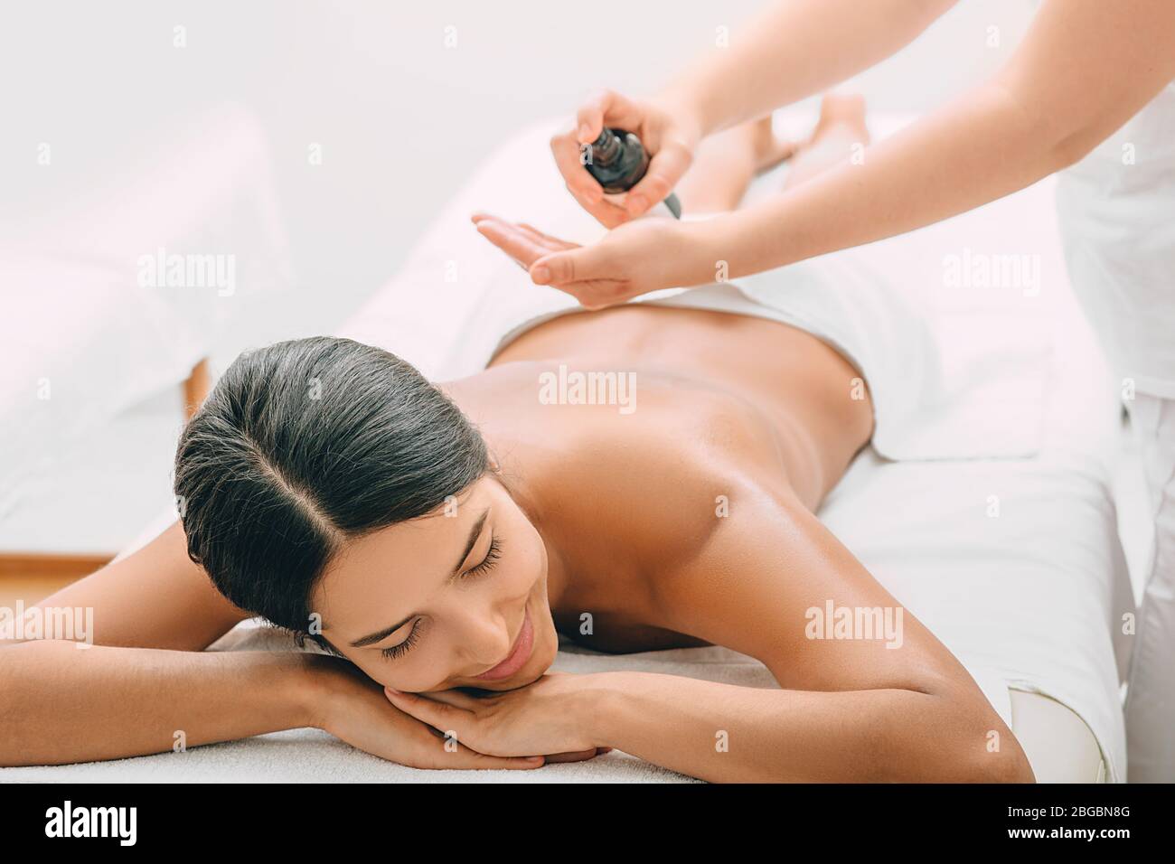 Belle femme qui aime le massage avec de l'huile d'arôme au spa. Banque D'Images
