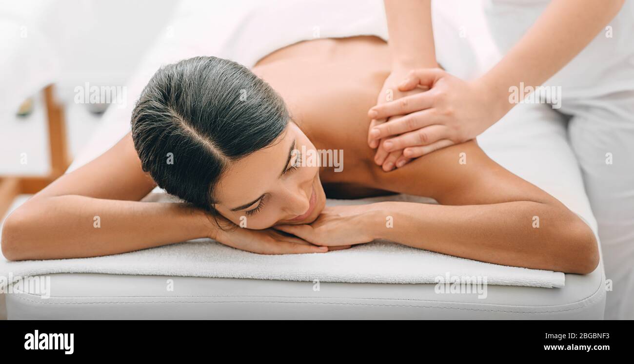 Femme de course mixte profitant d'un massage du dos, week-end de temps sur le spa. Femme de course mixte se détend pendant le massage du dos Banque D'Images
