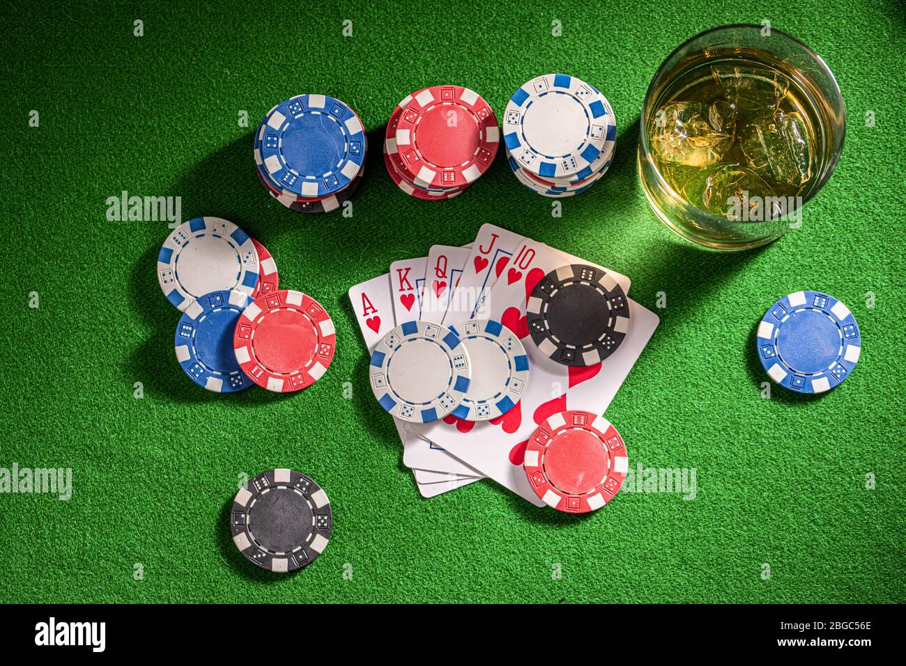 Table de jeu de quatre personnes avec whisky et cartes Banque D'Images