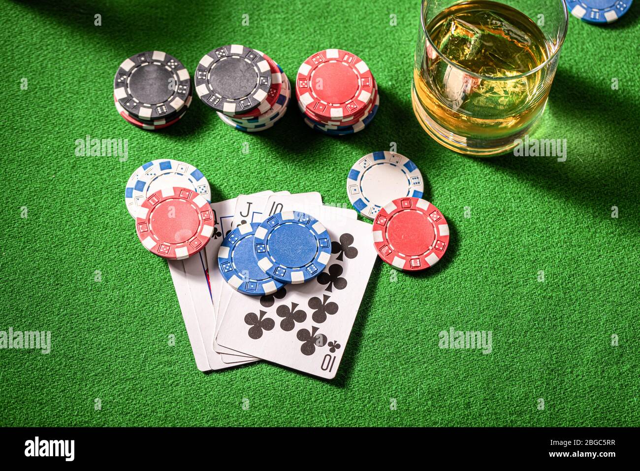 Whisky et cartes sur la table verte pour le poker Banque D'Images