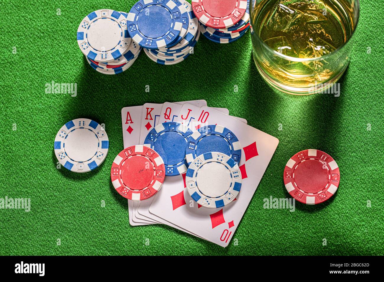 Table de jeu de quatre personnes avec whisky et cartes Banque D'Images