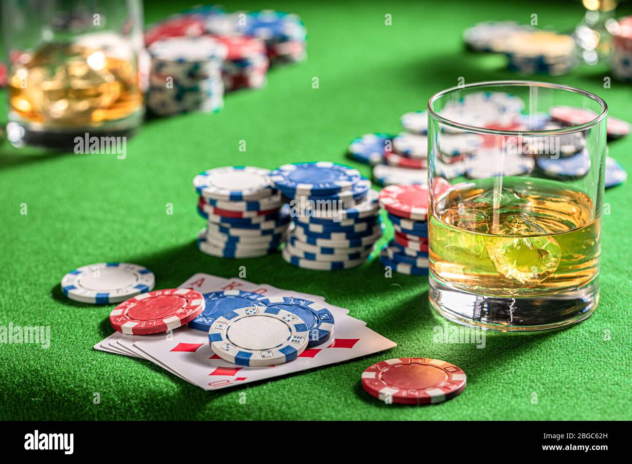 Table de jeu verte avec whisky et cartes Banque D'Images