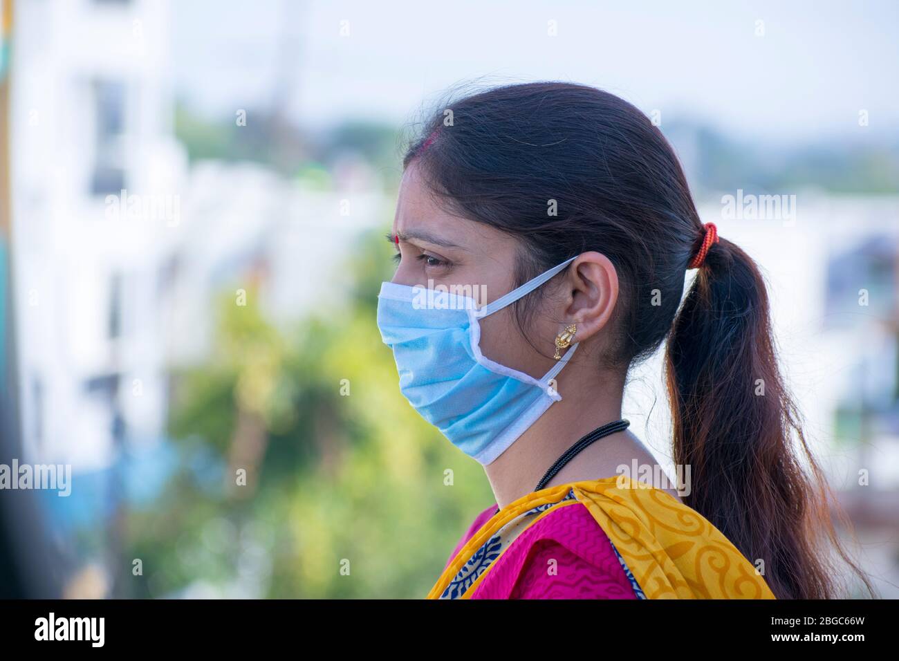 Gros plan sur un masque médical de coronavirus porté par une jeune femme indienne - vue latérale grippe, SRAS, Covid 19, protection antivirus Banque D'Images