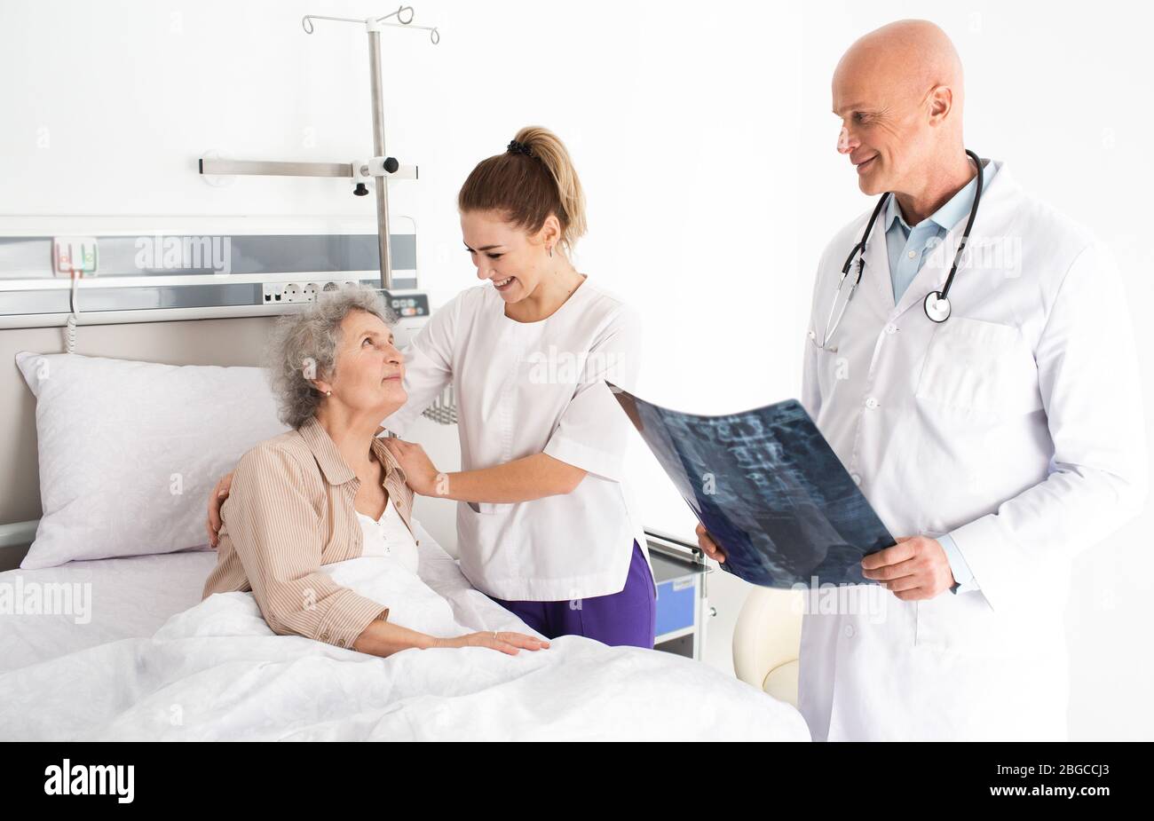 Soins médicaux à propos des personnes âgées patient âgé allongé dans un lit d'hôpital, ayant un soutien infirmier. Traitement et soins cliniques pour les personnes âgées Banque D'Images