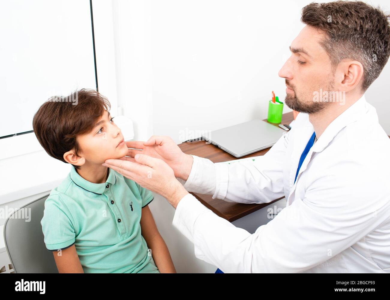 le pédiatre vérifie les ganglions lymphatiques d'un garçon. Amygdalite, inflammation des amygdales, Banque D'Images