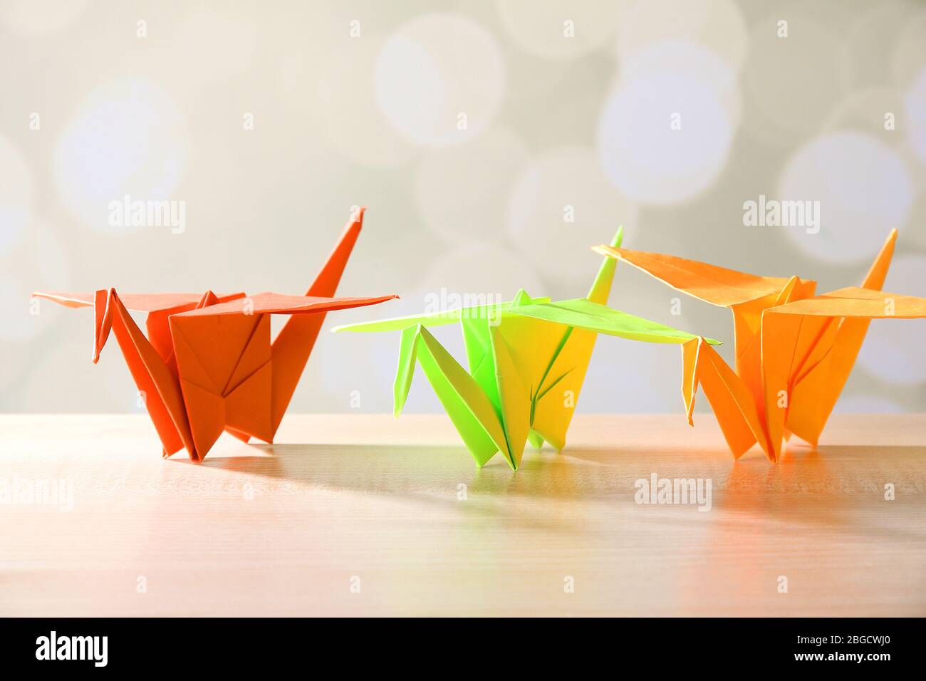 Grues Origami sur table en bois, sur fond clair Banque D'Images