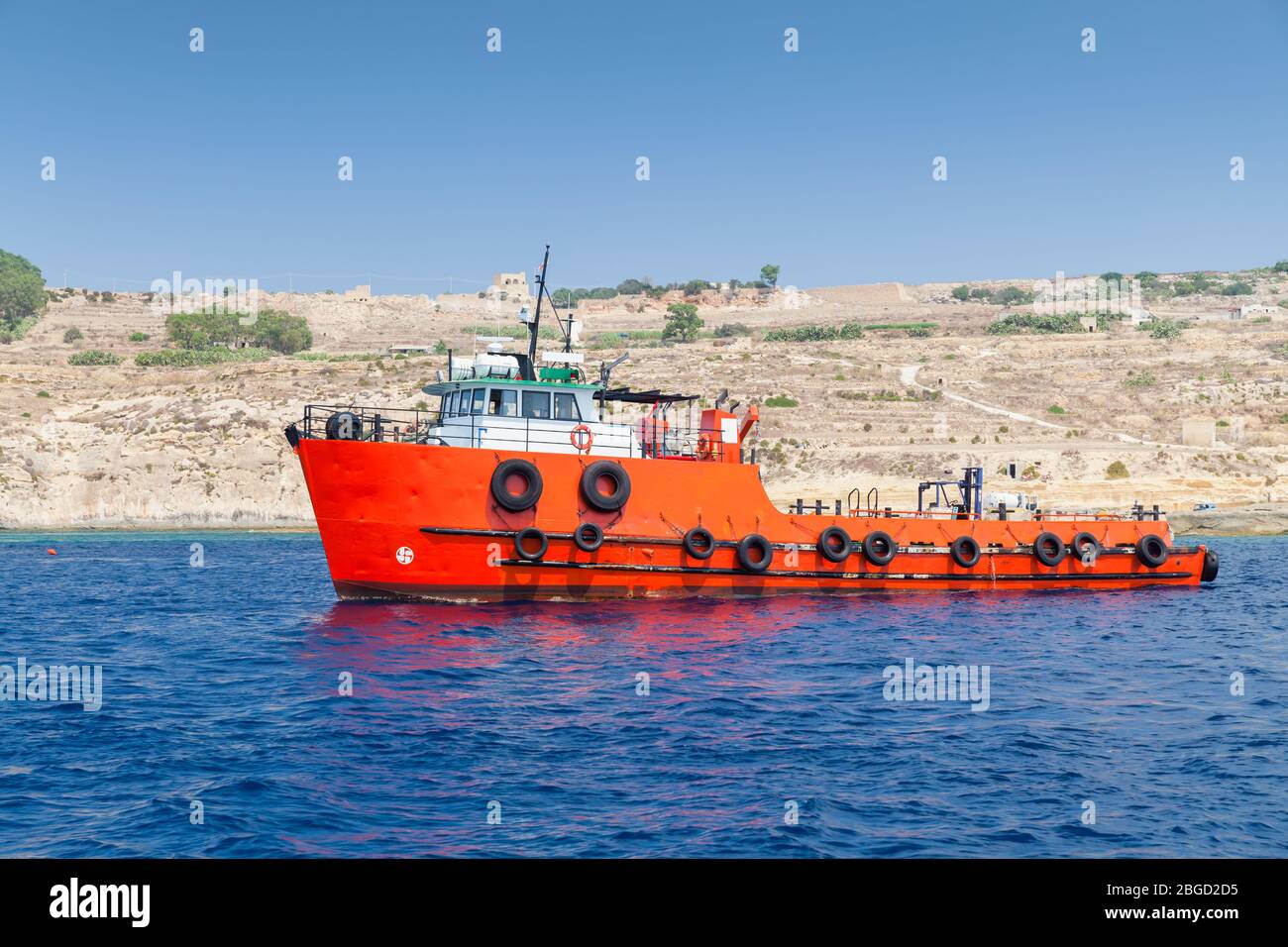 Bateau remorqueur avec coque rouge vif va à la mer Méditerranée, île de Malte Banque D'Images
