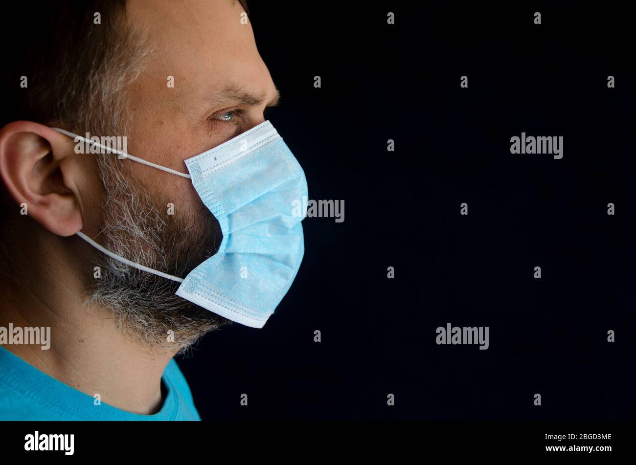 Le visage d'un homme dans un masque médical de protection bleu Banque D'Images