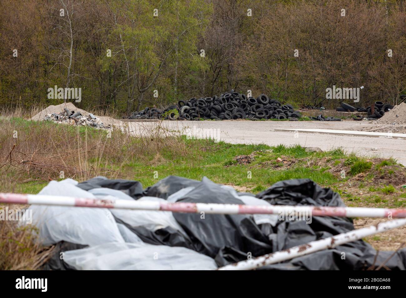 Décharge illégale près de la route de campagne dans le pays le jour ensoleillé. Banque D'Images