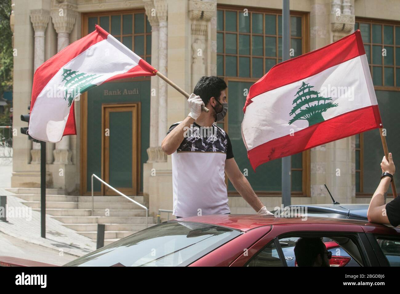 Beyrouth, Liban. 21 avril 2020. Les manifestants anti-gouvernementaux manifestent dans un convoi de voitures avec des conducteurs qui ont fait des loupes brandissant le drapeau national et se penchant sur les fenêtres avec des masques de visage lorsqu'ils traversent le centre de Beyrouth pour protester contre la détérioration des conditions de vie et pour souligner la chute du niveau de vie qui a été Exacerbée par le déclenchement du verrouillage du coronavirus et par la pression exercée sur les politiciens depuis l’apparition de manifestations de masse en octobre dernier. Crédit: amer ghazzal/Alay Live Banque D'Images