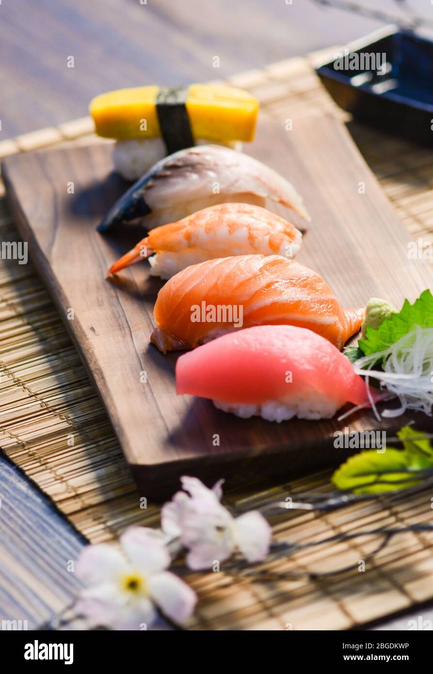 Mélanger les sushis sur le plat à bois, le thon, le saumon, le bar de mer, l'œuf sucré, Sushis aux crevettes, cuisine japonaise. Plats japonais sur l'assiette. Banque D'Images