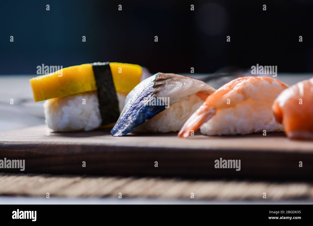 Mélanger les sushis sur le plat à bois, le thon, le saumon, le bar de mer, l'œuf sucré, Sushis aux crevettes, cuisine japonaise. Plats japonais sur l'assiette. Banque D'Images