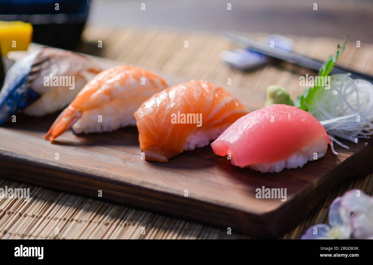 Mélanger les sushis sur le plat à bois, le thon, le saumon, le bar de mer, l'œuf sucré, Sushis aux crevettes, cuisine japonaise. Plats japonais sur l'assiette. Banque D'Images