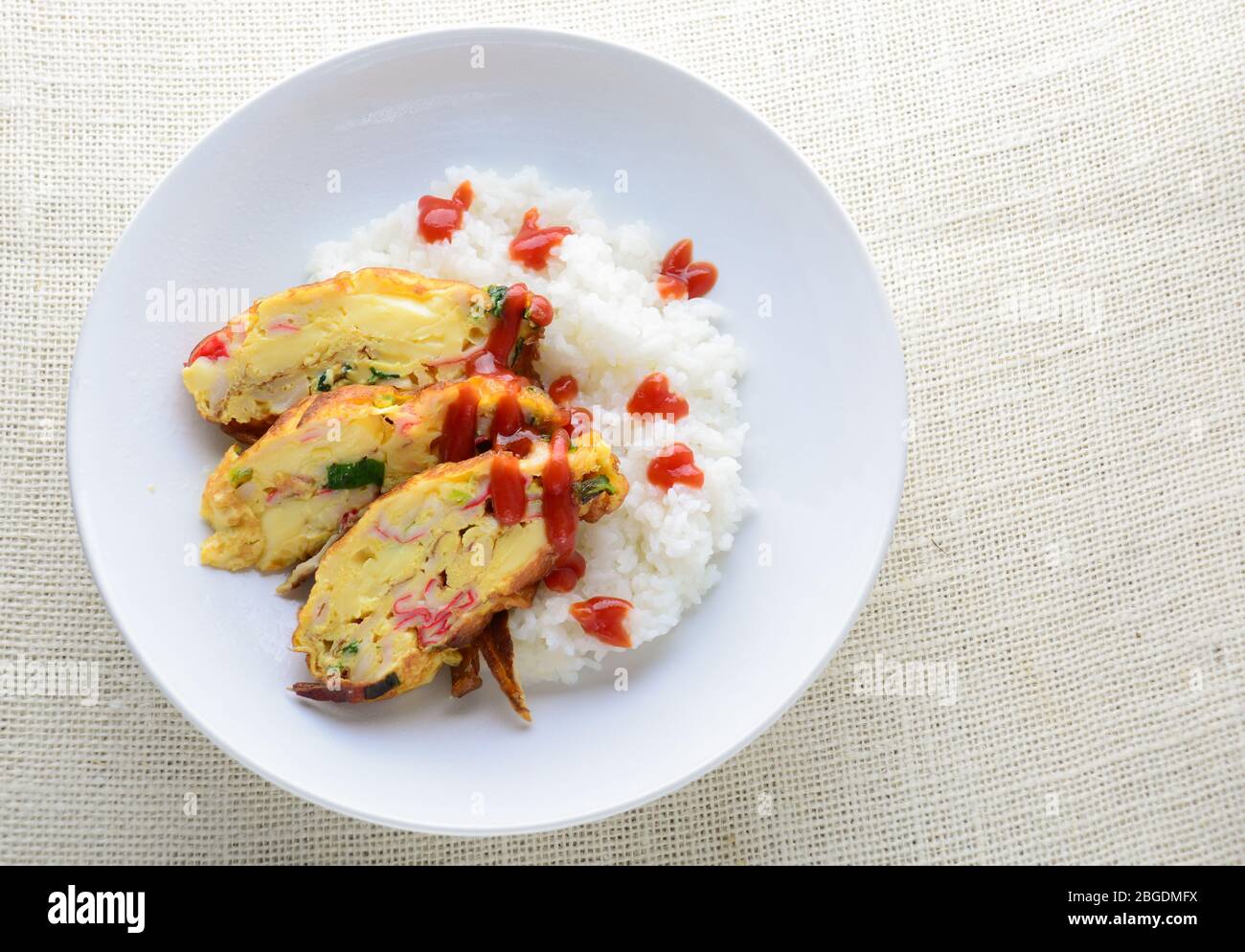 Omelette en tranches avec tofu doux, croque de crabe et oignon de printemps avec riz sur plat Banque D'Images