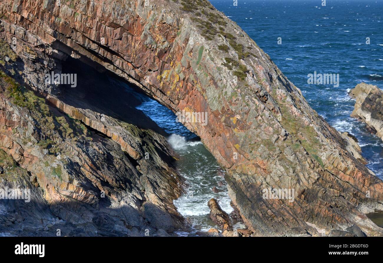 PORTKNOCKIE MORAY FIRTH ECOSSE L'ARCHE D'UNE PILE DE MER CONNUE SOUS LE NOM DE LA BOUCHE DES BALEINES ET D'UNE MARÉE ENTRANTE Banque D'Images