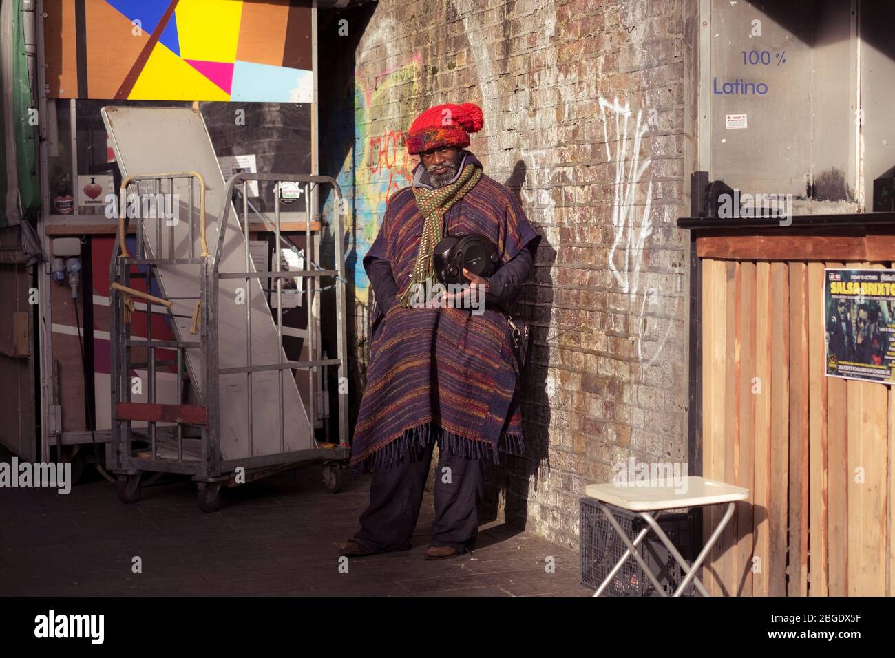 Un homme portant un manteau et tenant une boombox à Brixton, Londres Banque D'Images