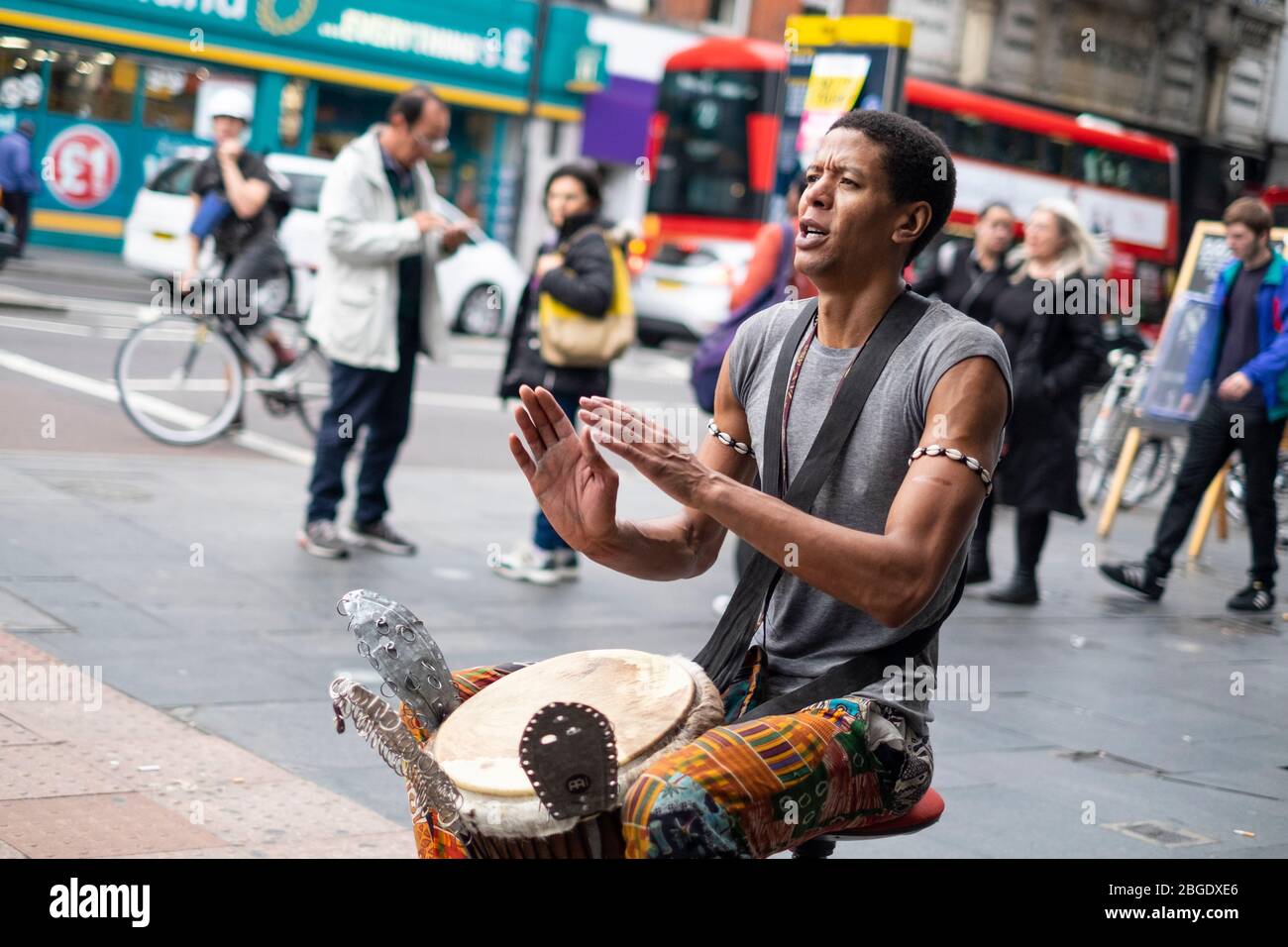 Un buker masculin jouant un tambour à main devant la station de métro Brixton, Londres Banque D'Images