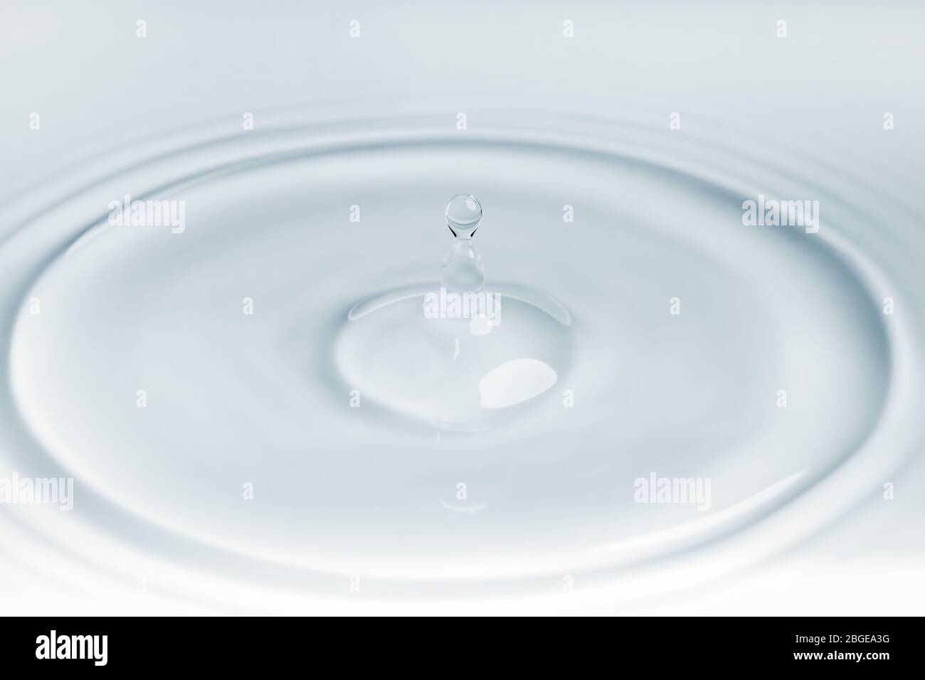 Petite goutte d'eau qui tombe sur un effet d'ondulation sur la surface de l'eau Banque D'Images