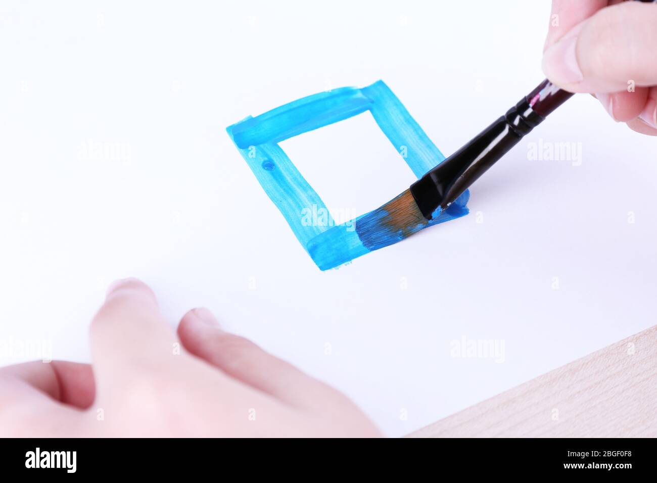 Enfant dessine la maison avec des aquarelles, gros plan Banque D'Images