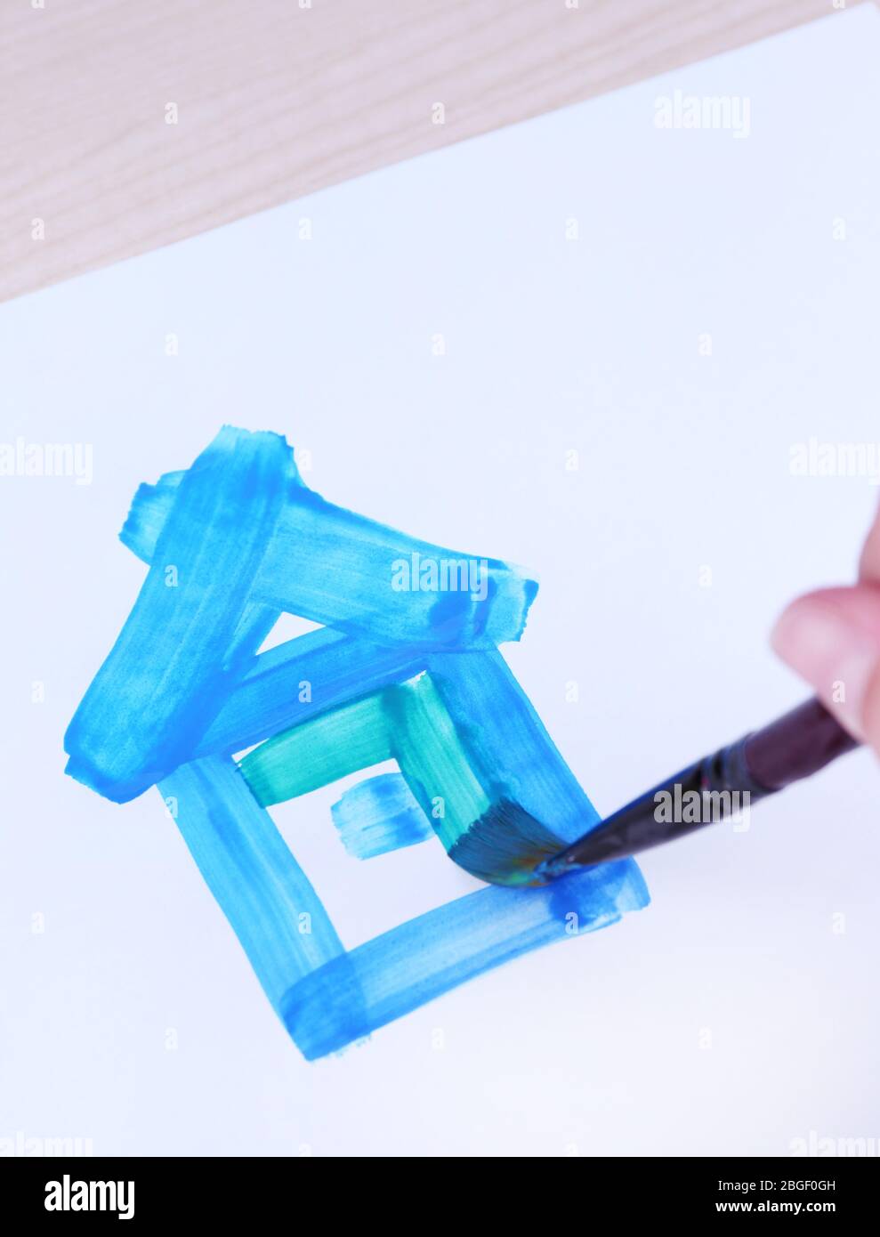 Enfant dessine la maison avec des aquarelles, gros plan Banque D'Images