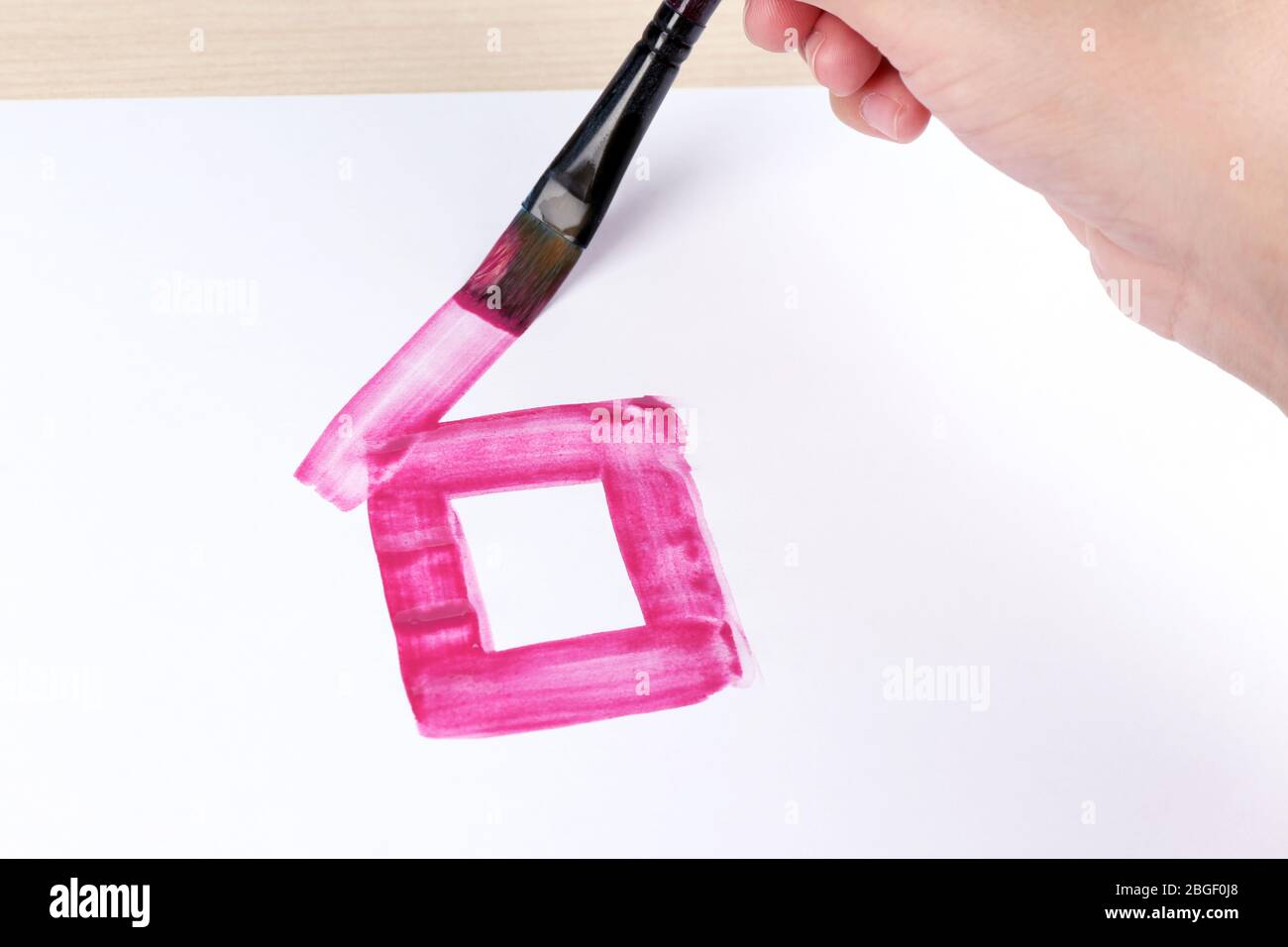 Enfant dessine la maison avec des aquarelles, gros plan Banque D'Images