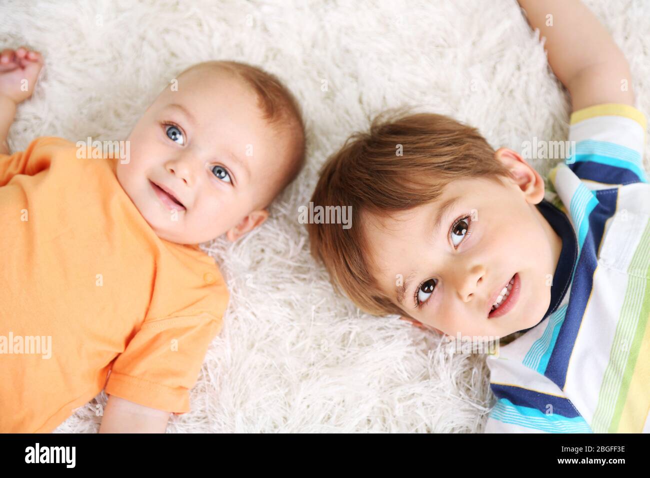 Mignons petits garçons sur la moquette Banque D'Images