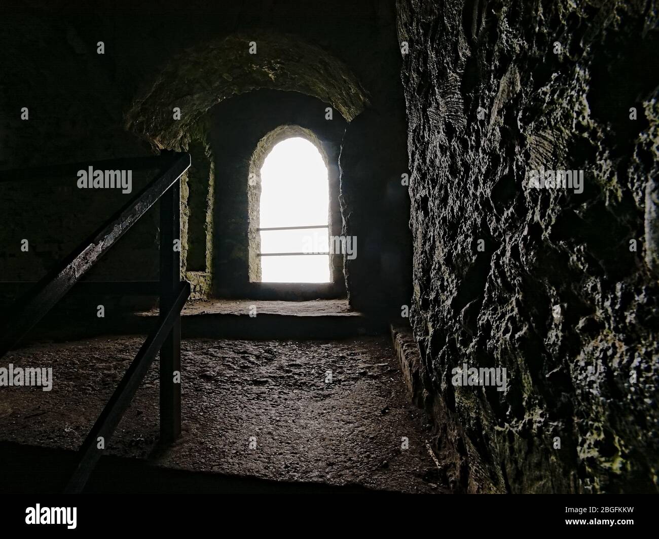 Fenêtre de voûte dans les vieux journaux de chasse fortifiés du club de tir Hell à Dublin, Irlande , vue de l'intérieur avec lumière vive brillant brillant brillant sur les murs épais de granit Banque D'Images