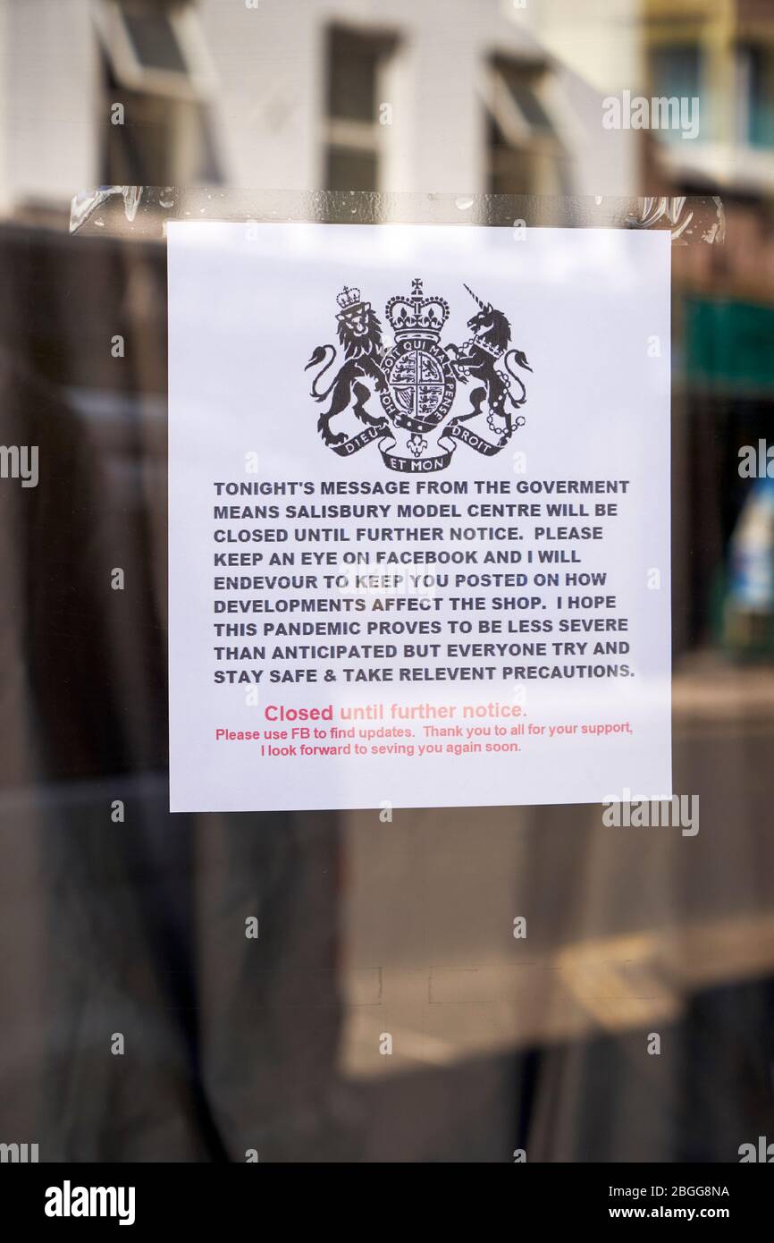 L'écusson royal sur l'avis dans la fenêtre de l'atelier informant les clients de la fermeture due à Coronavirus Banque D'Images