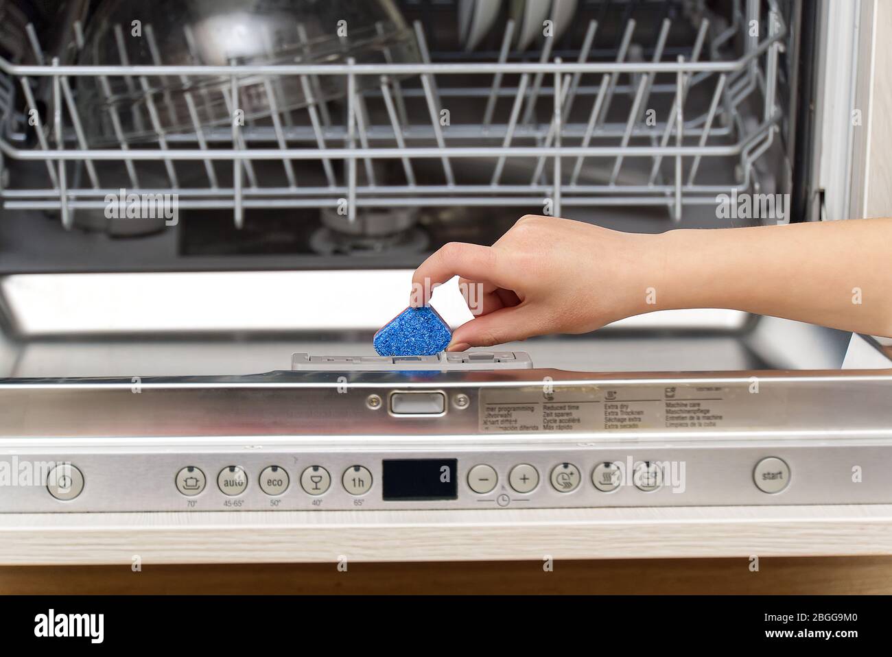 La languette de fixation dans le lave-vaisselle intégré se ferme. Lave- vaisselle pleine charge. Femme tenant la main de la tablette de détergent  pour lave-vaisselle Photo Stock - Alamy