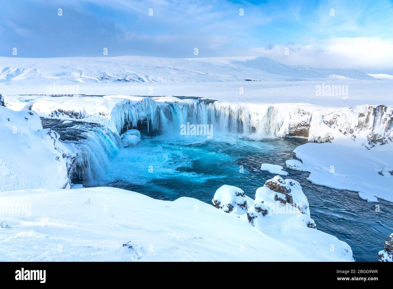 La rivière islandaise à moitié gelée Skjalfandafljot qui coule au-dessus de la cascade Godafoss en hiver. Toujours très fluide mais neige couverte et avec de grandes iciques Banque D'Images