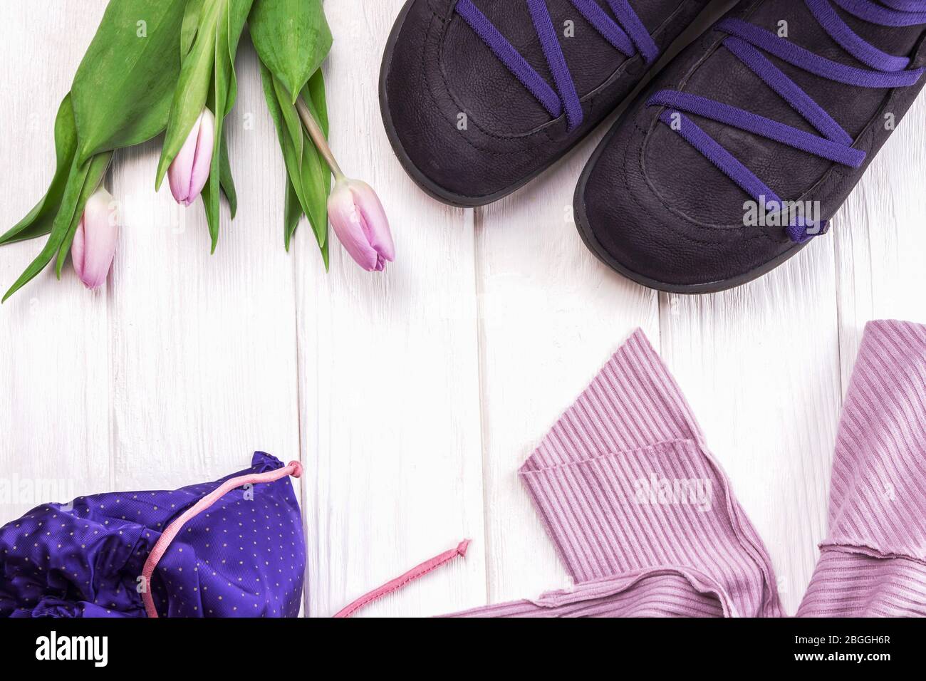 Chaussures, vêtements et fleurs printanières élégantes tulipes sur fond  blanc en bois. Plat laïque de vêtements de printemps pour filles Photo  Stock - Alamy