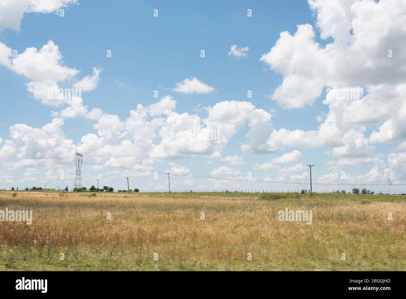 Paysage routier, été, ciel bleu et nuages blancs, lignes électriques et pylônes Banque D'Images