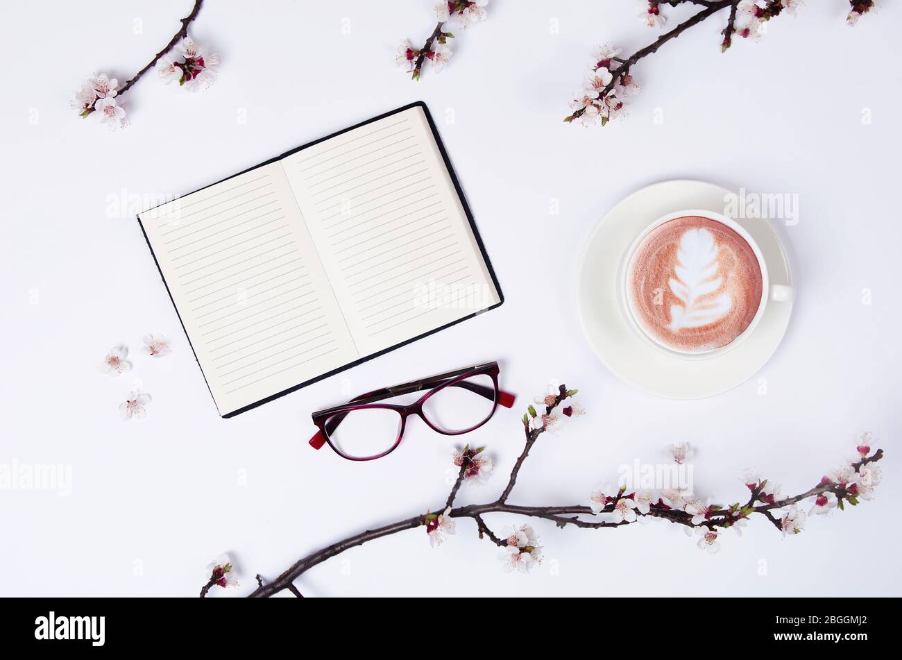 Liste de souhaits pour les plans futurs. composition de plat avec fleurs, verres et bloc-notes et café avec l'art latte Banque D'Images