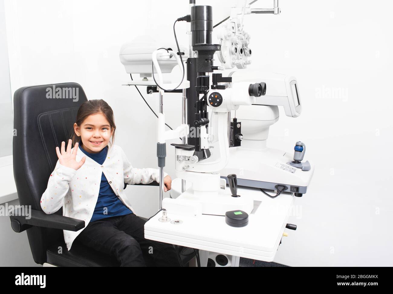 Petite fille patient dans le bureau de l'ophtalmologiste. La fille n'a pas peur de vérifier la vue dans une clinique médicale Banque D'Images